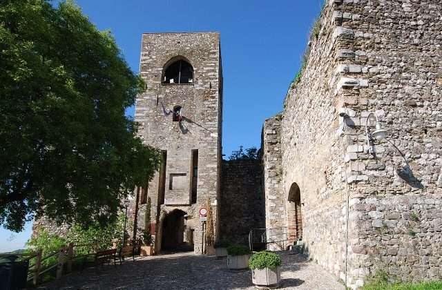 El Castillo medieval de Padenghe sul Garda con las murallas almenadas y la torre entre los olivos de la Valtenesi