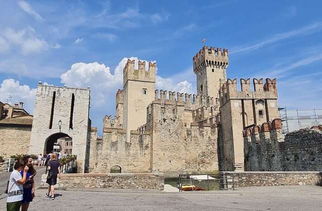 El Castello Scaligero de Sirmione rodeado por las aguas del Lago de Garda con las torres almenadas