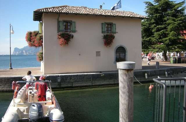 De oude haven van Torbole sul Garda met de Venetiaanse Douane en de Trentijnse bergen op de achtergrond
