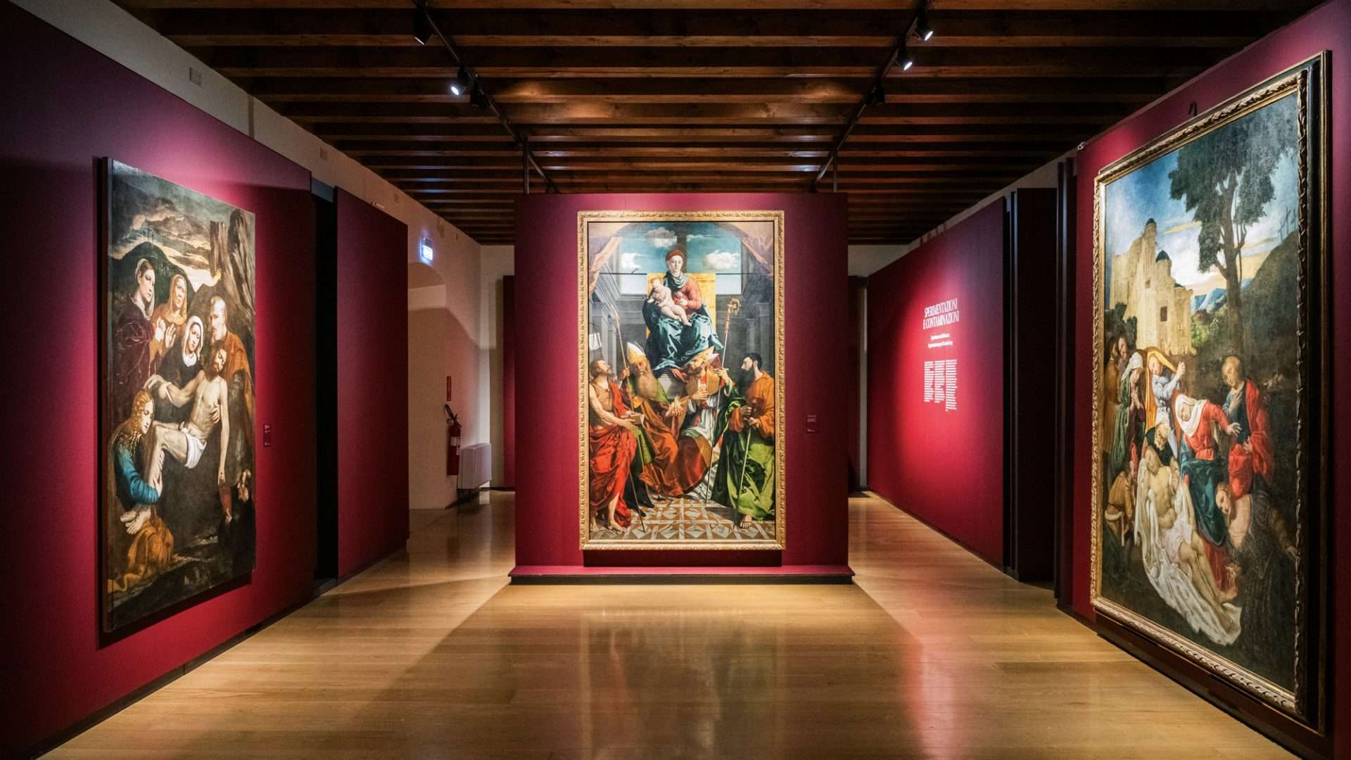 Ausstellungsraum des MAG mit alten Gemälden an roten Wänden