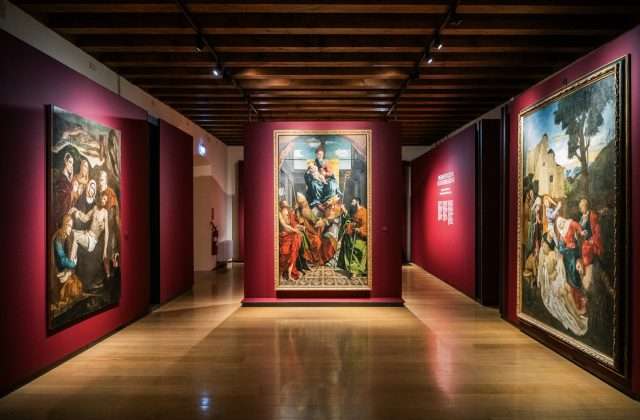 Ausstellungsraum des MAG mit alten Gemälden an roten Wänden