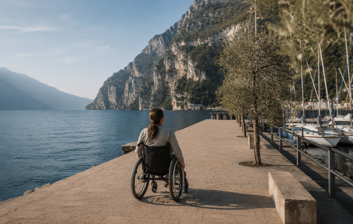 Donna in carrozzina sul lungolago di Riva del Garda con vista lago