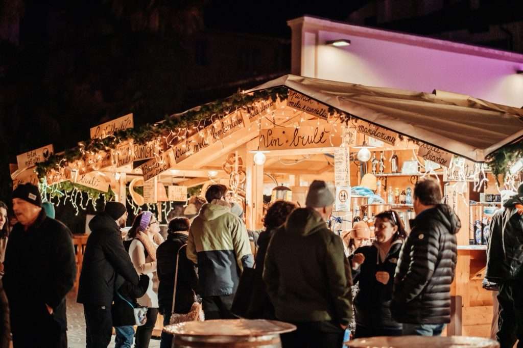 Personas ante la caseta de vino caliente del mercadillo de Navidad de Arco