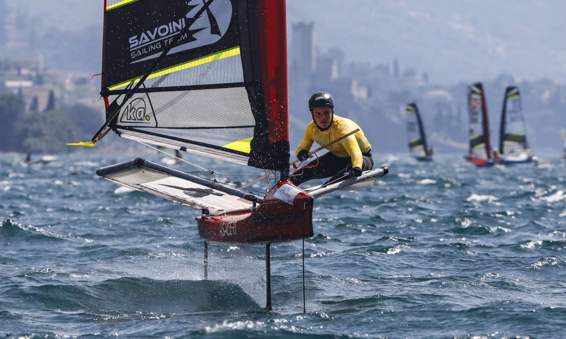 Un velista su un Waszp in volo sui foil davanti al castello di Malcesine