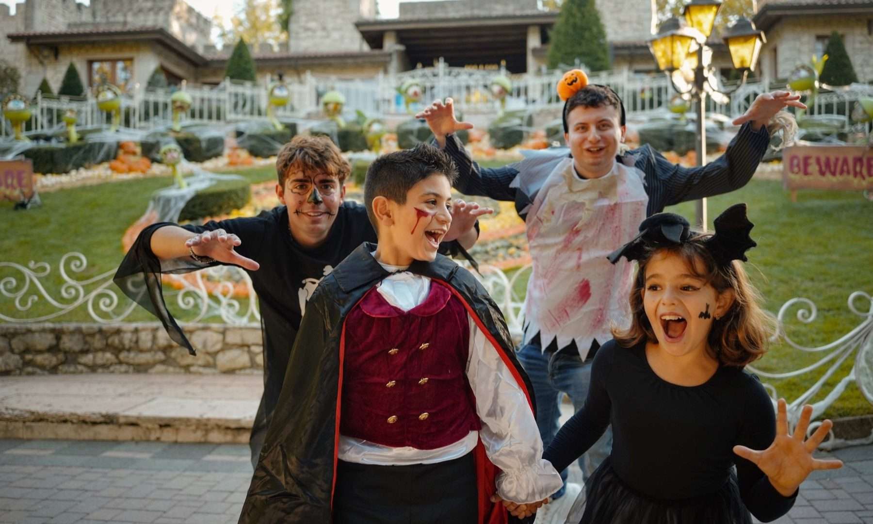 Ragazzi e bambini in costume da Halloween davanti al castello di Gardaland